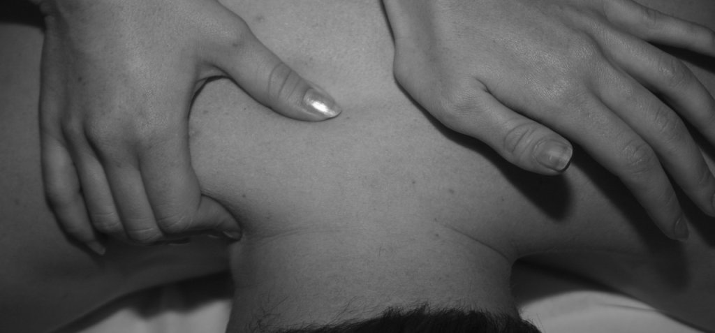 Photo of someone massaging back and body pain