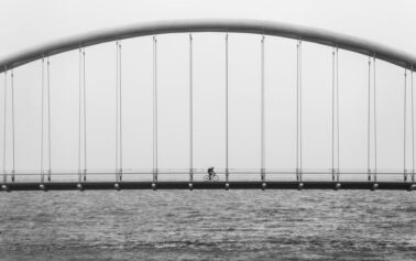 man biking on bridge