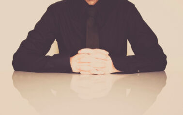 man in black shirt with fingers crossed