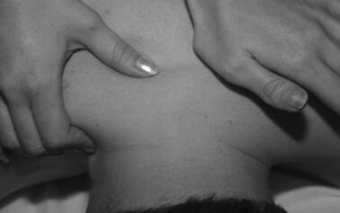 Photo of someone massaging back and body pain