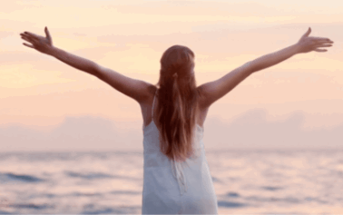 A woman on a beach at sunset